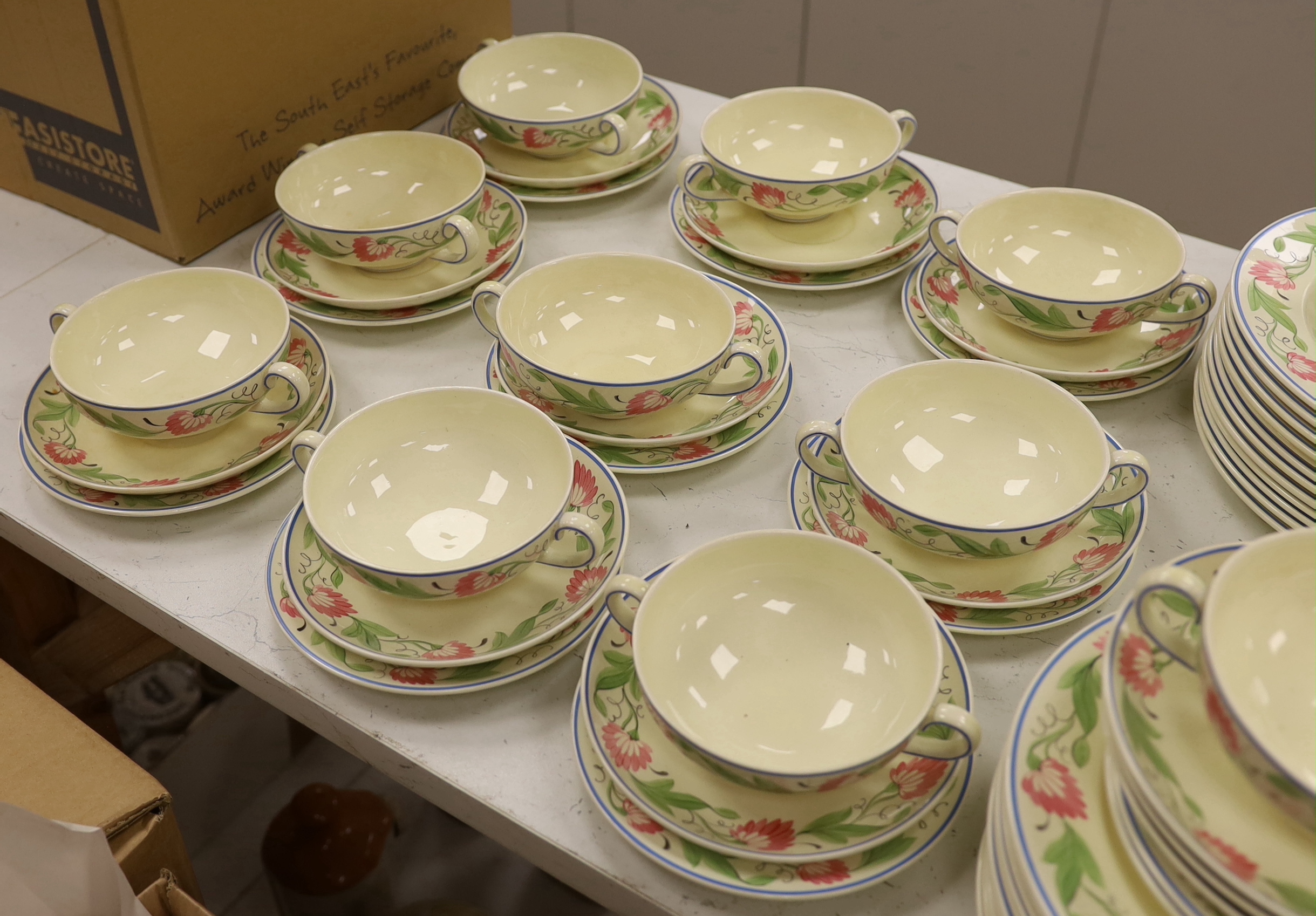 A Wedgwood floral pattern dinner service, c.1934 including twin handled cups, dinner plates and serving dishes, largest 42cm wide